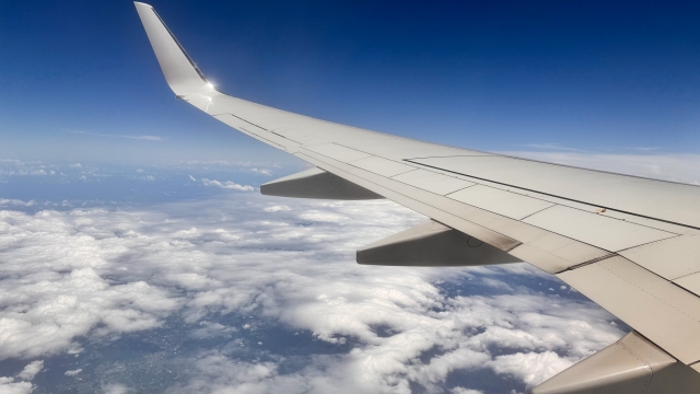 飛行機の窓から見える青空と雲、旅立ちのイメージ